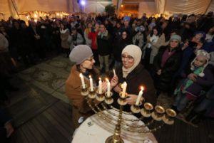 Jews and Arabs light candles at the First Station compound in Jerusalem on December 10, 2015, during the Jewish holiday of Hanukkah. Hanukkah, also known as the Festival of Lights, is an eight-day Jewish holiday commemorating the rededication of the Holy Temple. The festival is observed by the kindling of the lights of a 'hanuckia'- a nine-branched candelabrum, with one additional light being lit on each night of the holiday. Photo by Yossi Zamir/Flash90 *** Local Caption *** ????? ???? ????? ?????? ????? ?? ????